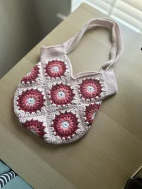 The Marguerite tote, held by the strap
